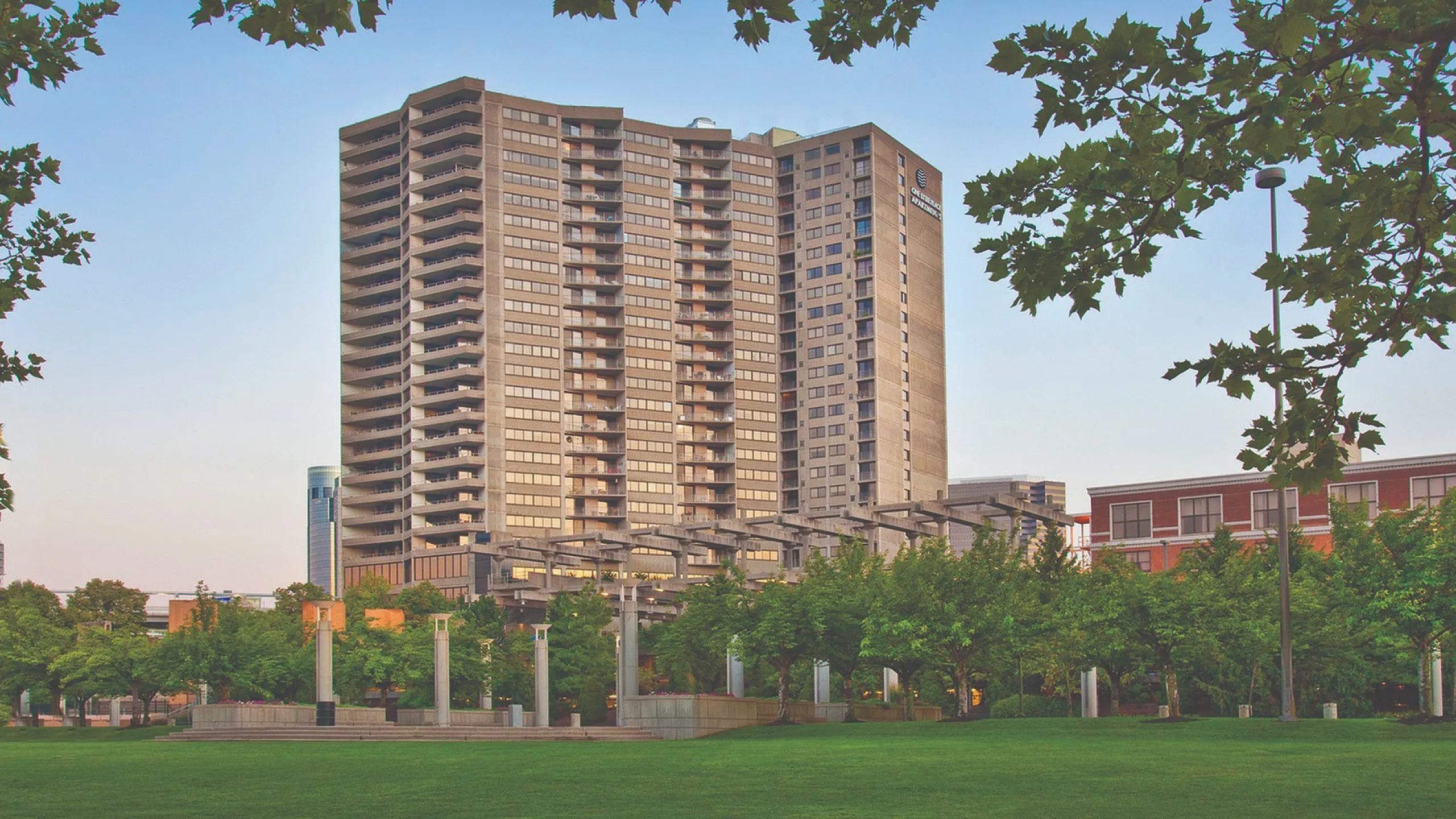 Elegant high-rise apartment building with expansive views, lush green surroundings, and modern architectural design.