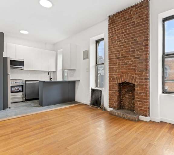 A room with a fireplace and a wooden floor.