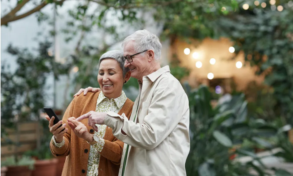 Elderly couple looking at a cellphone outside