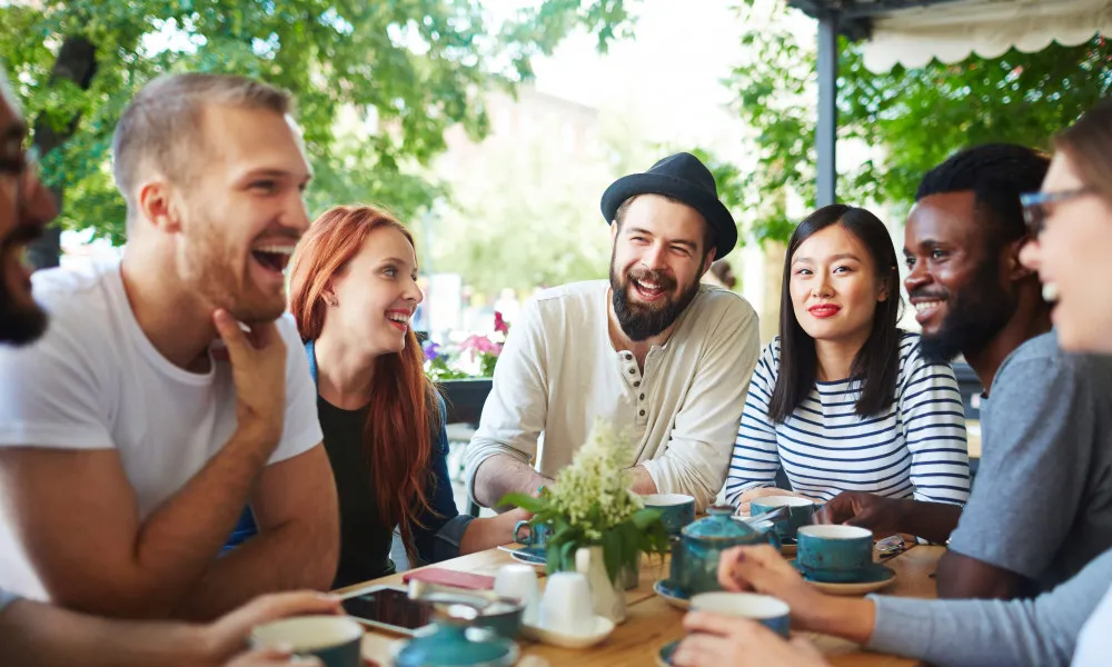 Group of friends conversing on a restaurant patio