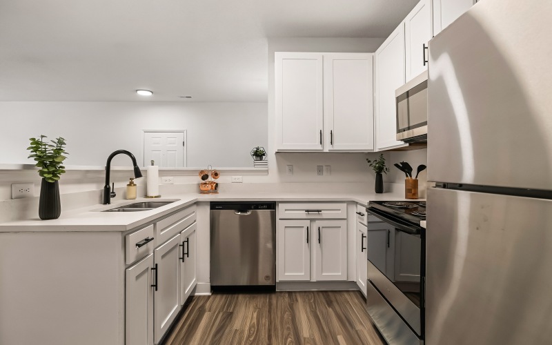 A kitchen with a sink, dishwasher, and fridge