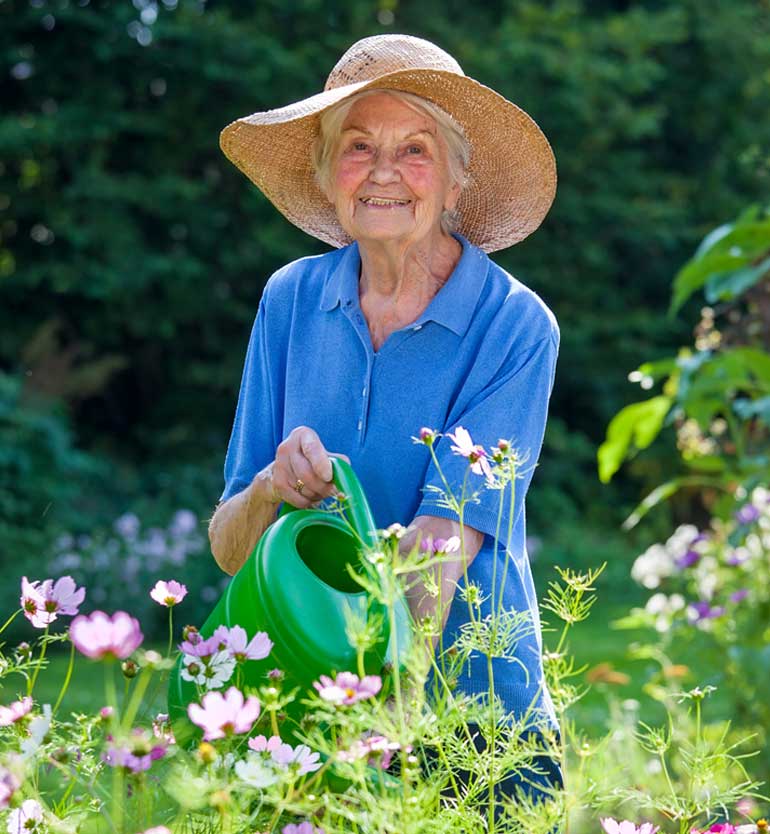 senior wearing a sun hat and blue shirt gardening