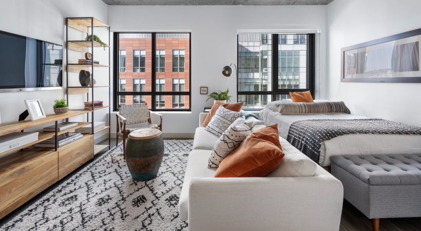 a living room with a couch, tv and a bed