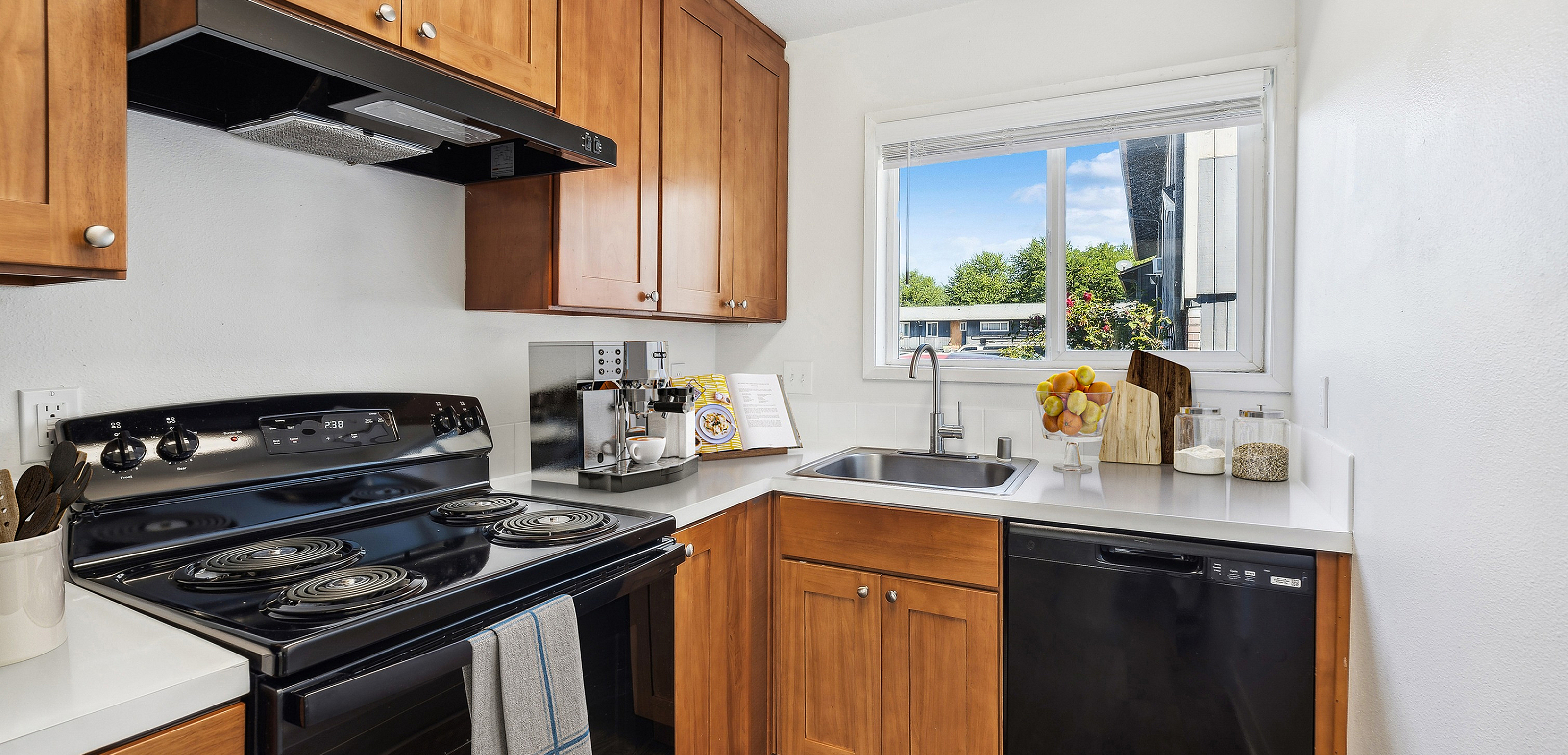 Bright and inviting kitchen with wooden cabinets, modern appliances, and a window view.