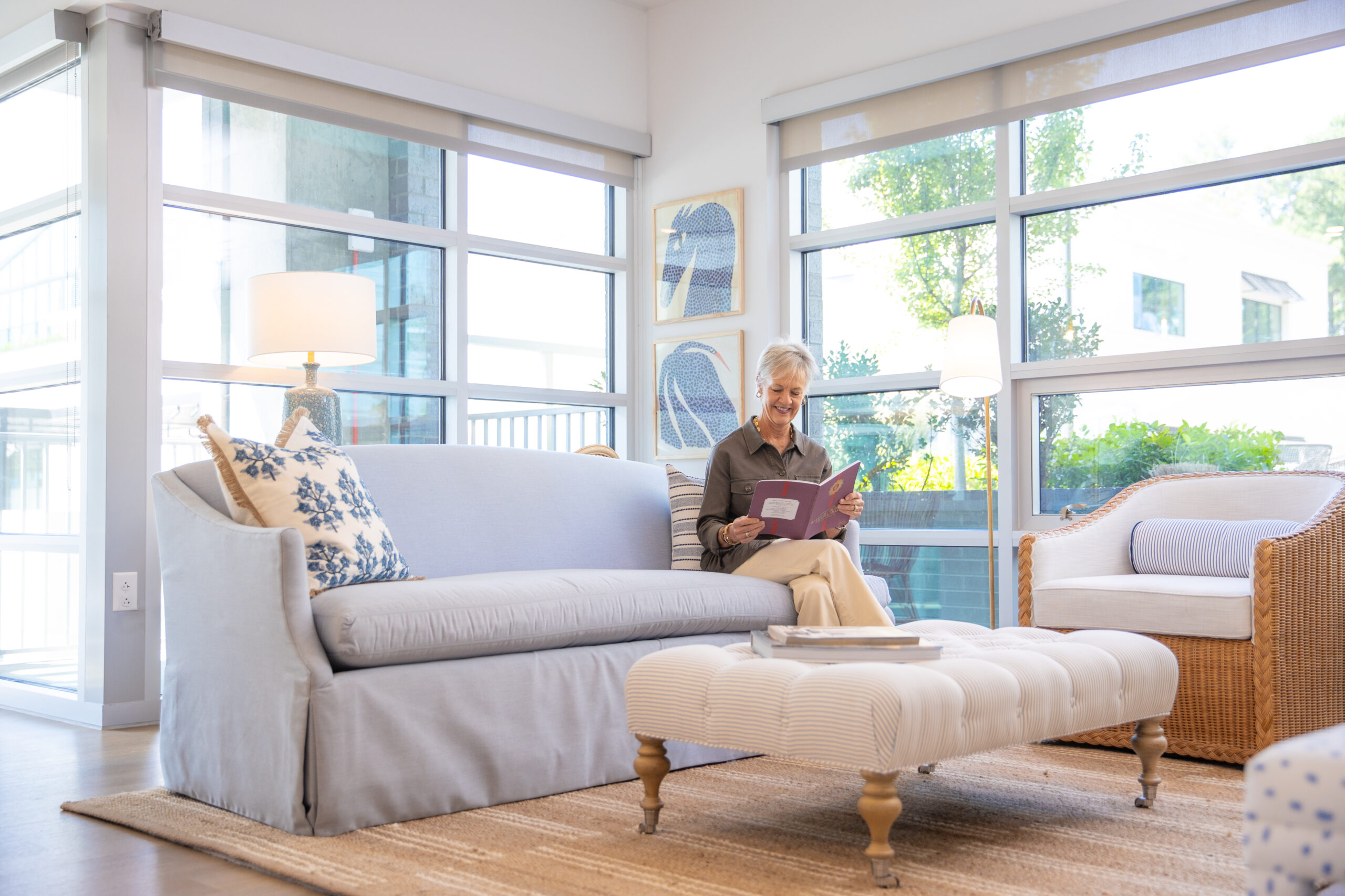 Woman sitting on a couch in a furnished apartment in Highland North Hills in Raleigh, NC