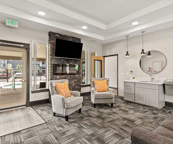 A living room with a grey couch, a chair, and a television.