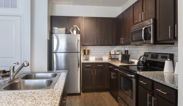 Kitchen with stainless steel appliances at 4 Corners Frisco apartments.