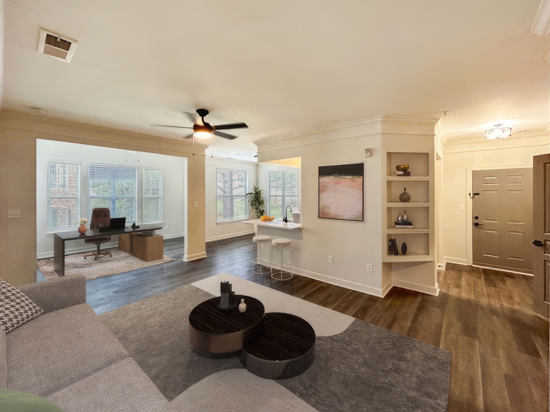 Modern living room with an open home office area and large windows.