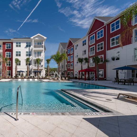 A large swimming pool in front of apartment buildings.