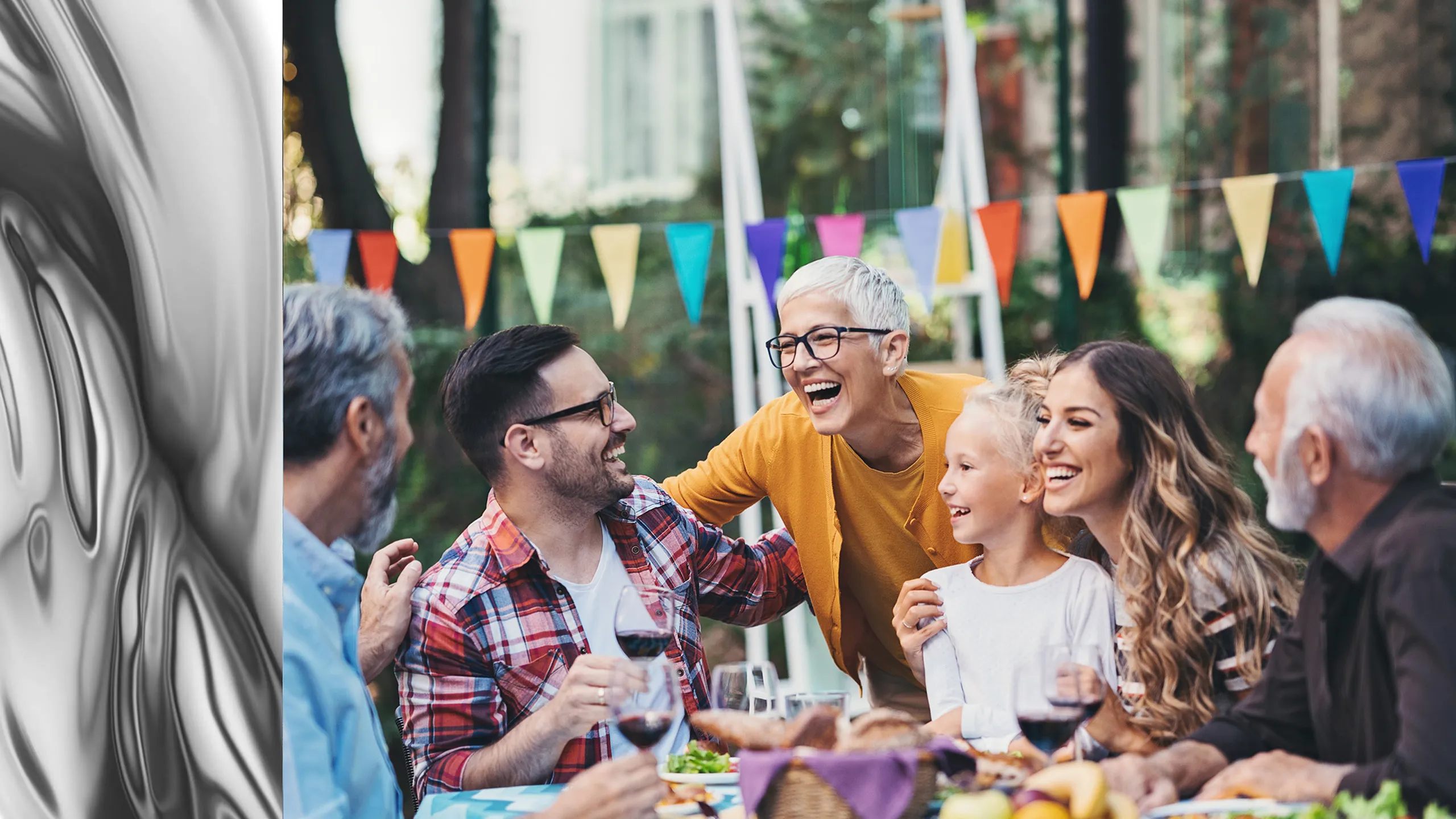 Joyful outdoor gathering with diverse group of people enjoying a vibrant party with colorful banners, good food, and laughter.