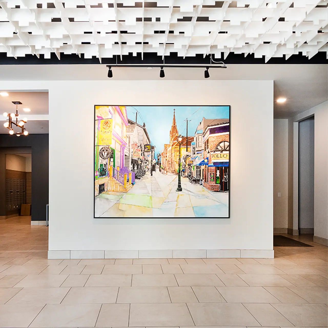 Interior of an art gallery featuring a large painting on the wall, with a modern ceiling design and tiled floor.