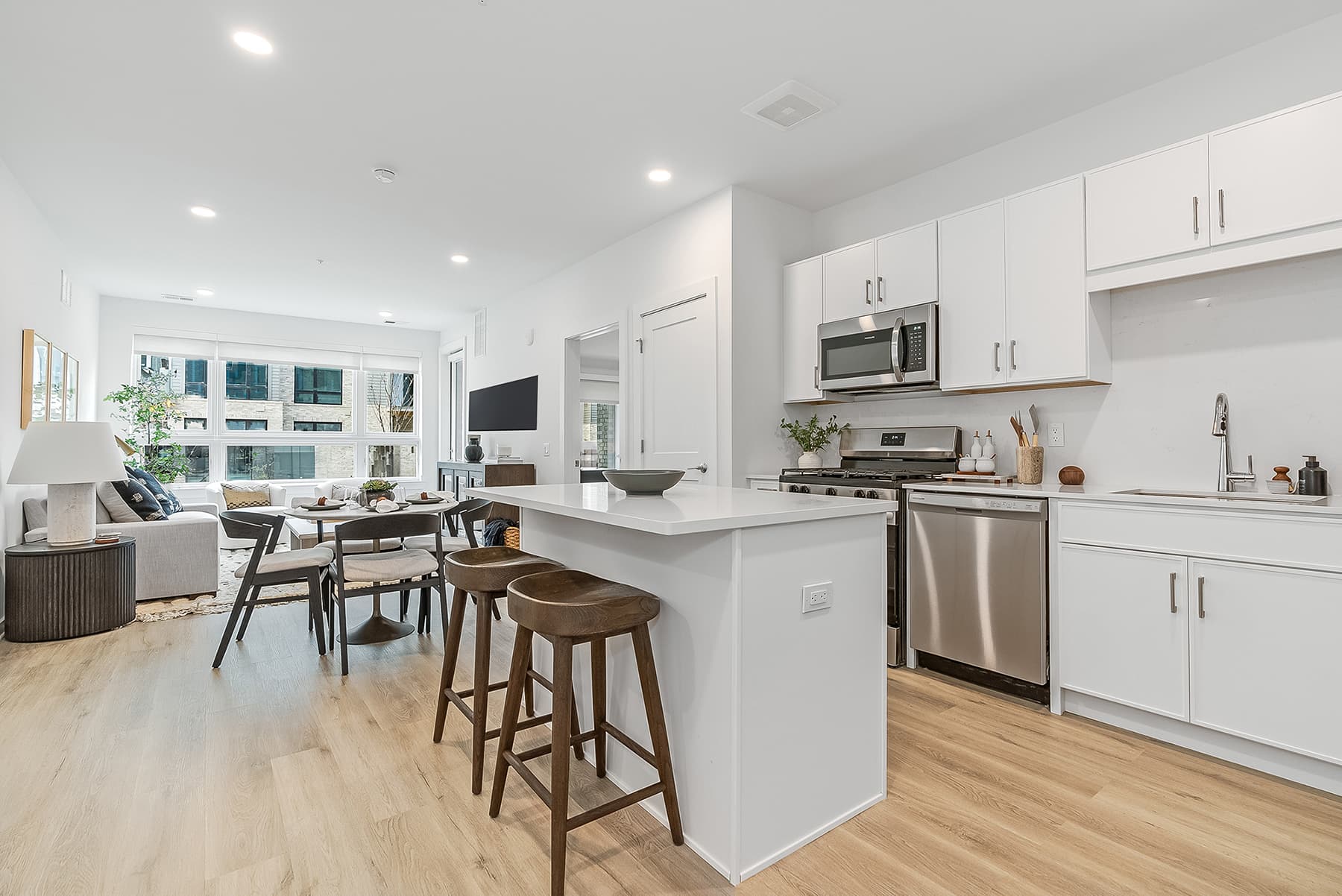 Open-concept kitchen and living room at Livana East Hanover, featuring modern finishes and stainless-steel appliances.