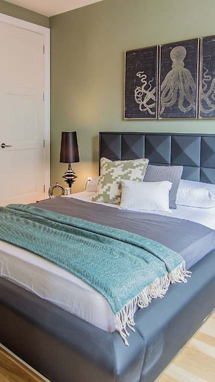 A bedroom with a bed, nightstand, and two lamps.