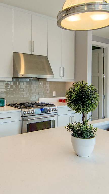 A kitchen with white cabinets and a white countertop.