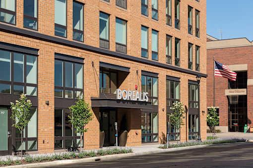 A Borelis storefront with a brick facade and an American flag.
