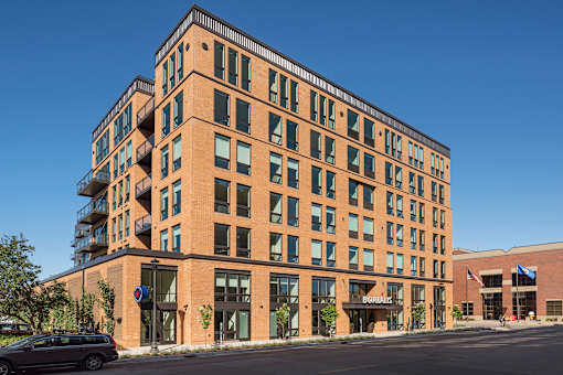 A large brick building with a balcony on the top floor.