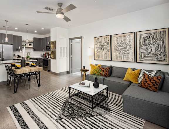 A modern living room with a grey couch and a black and white striped rug.