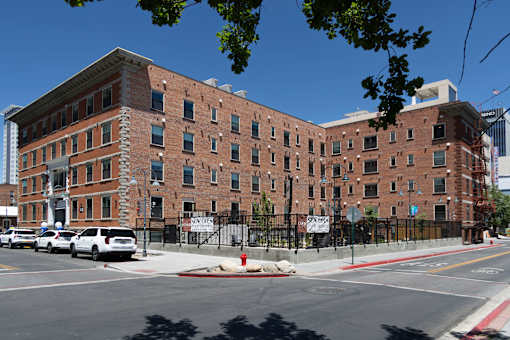 A large brick building with a black fence in front of it.