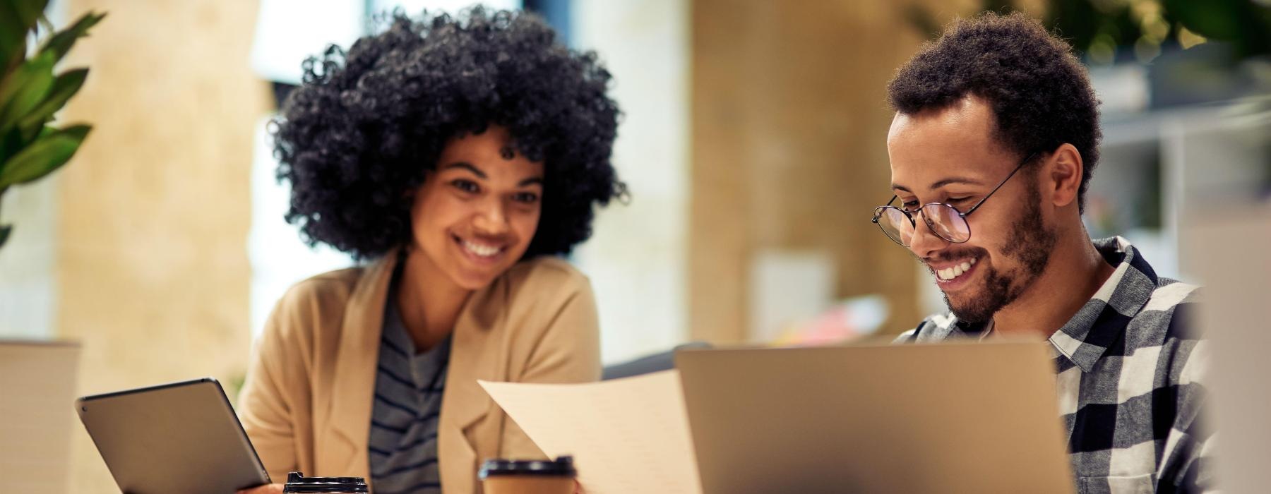 a man and a woman looking at a laptop