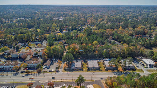 An aerial view of a suburban area with a road intersection and apartment buildings.