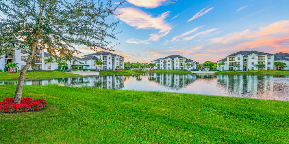 Apartments by pond at sunset at Evergreen Estero in Fort Myers, Florida