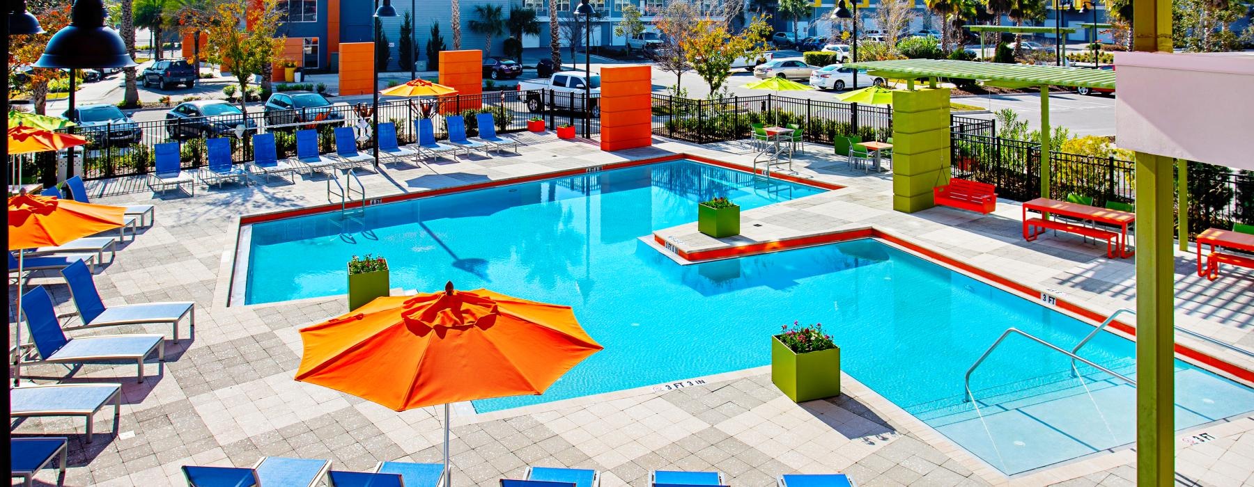 a pool with chairs and umbrellas