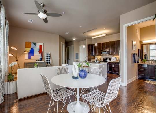 A modern dining room with a white table and chairs.