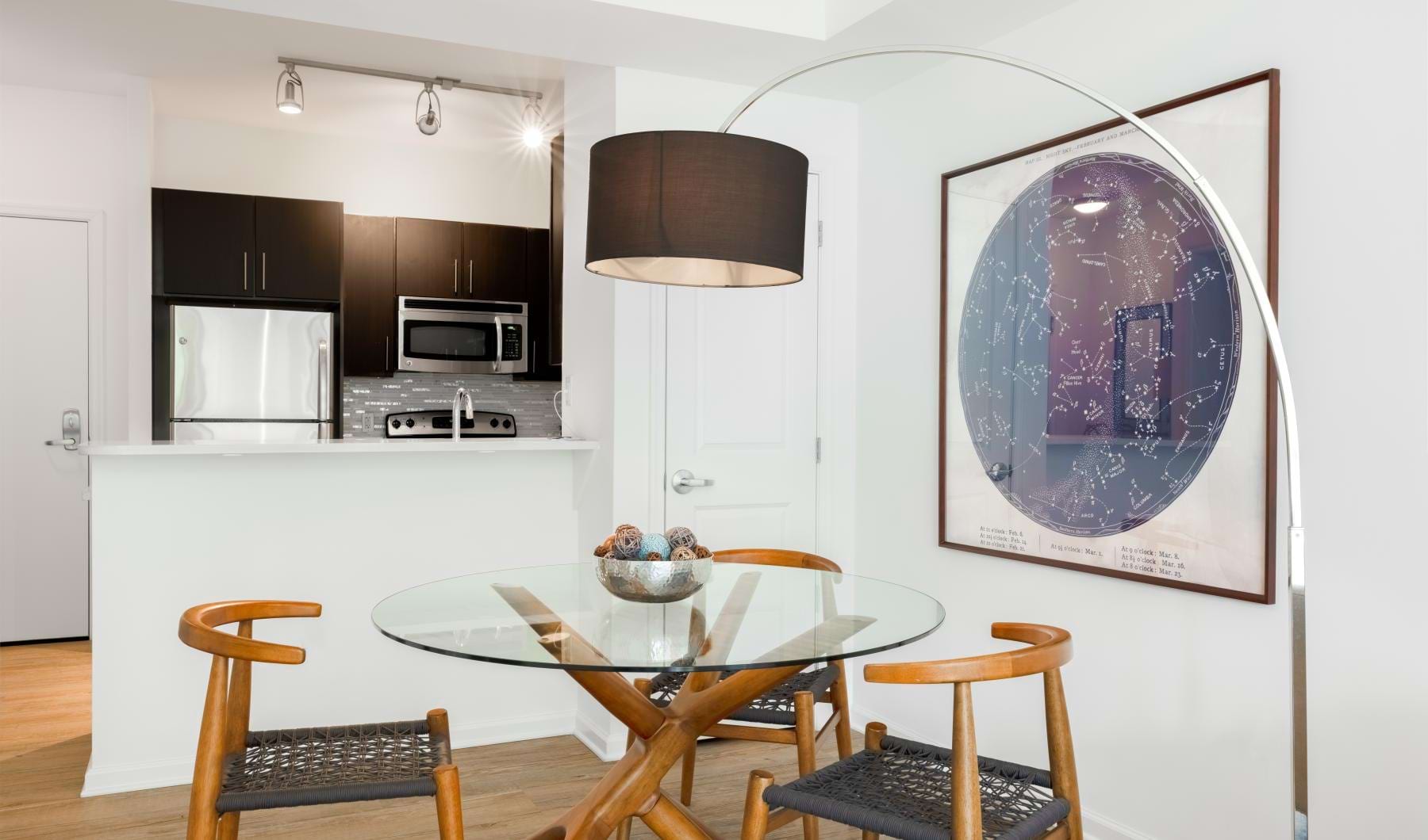 Kitchen and dining area with glass table and chairs at 14W apartments in Washington DC.