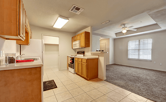 A kitchen with wooden cabinets and a white countertop.