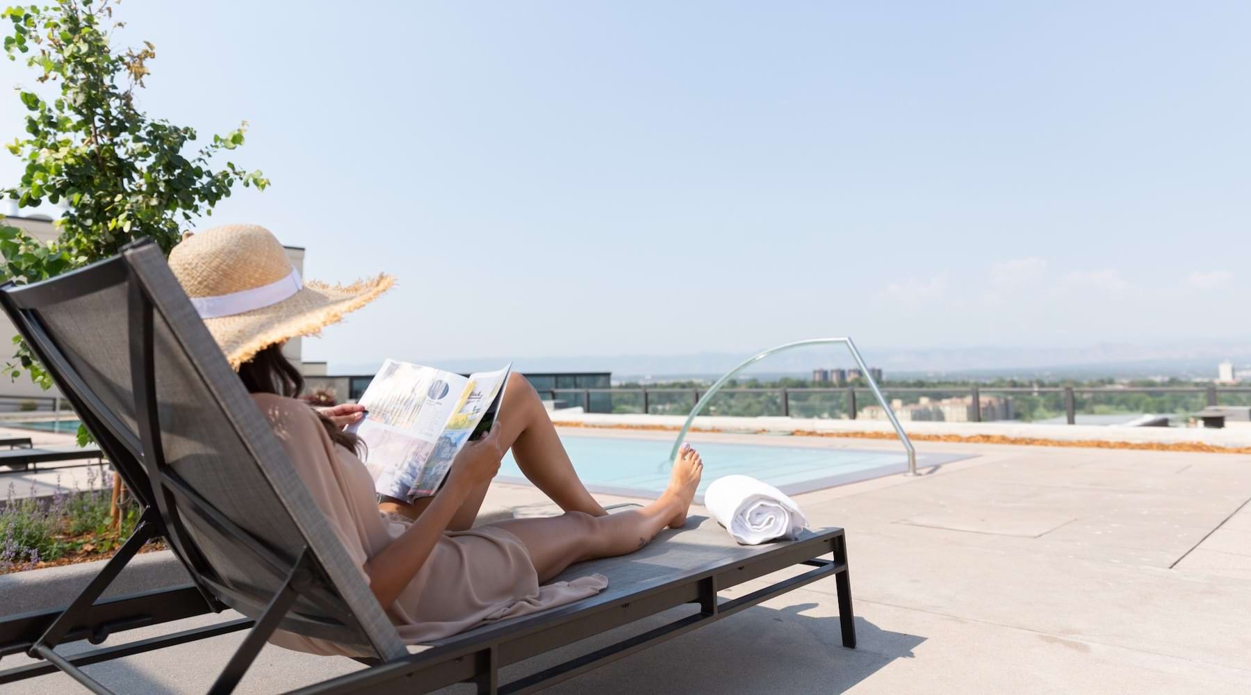 a person relaxing by a pool in a lounge chair