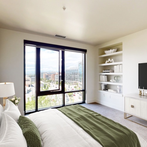 a bedroom with a bed and a tv on a dresser