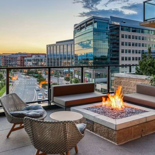 a patio with a fire pit and chairs