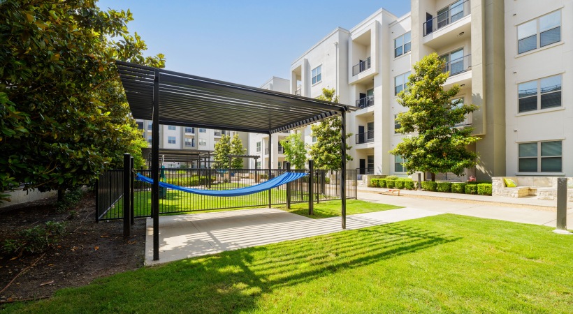 The outdoor lounge at Maple District Lofts features a hammock and shade