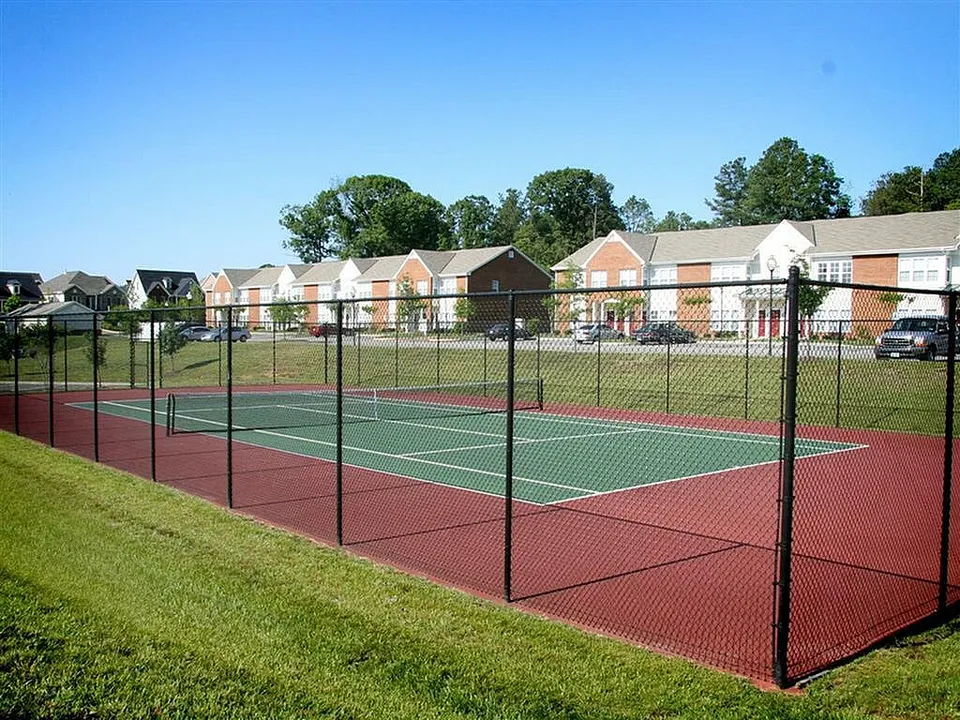 Inviting tennis court nestled within a vibrant residential community on a sunny day.