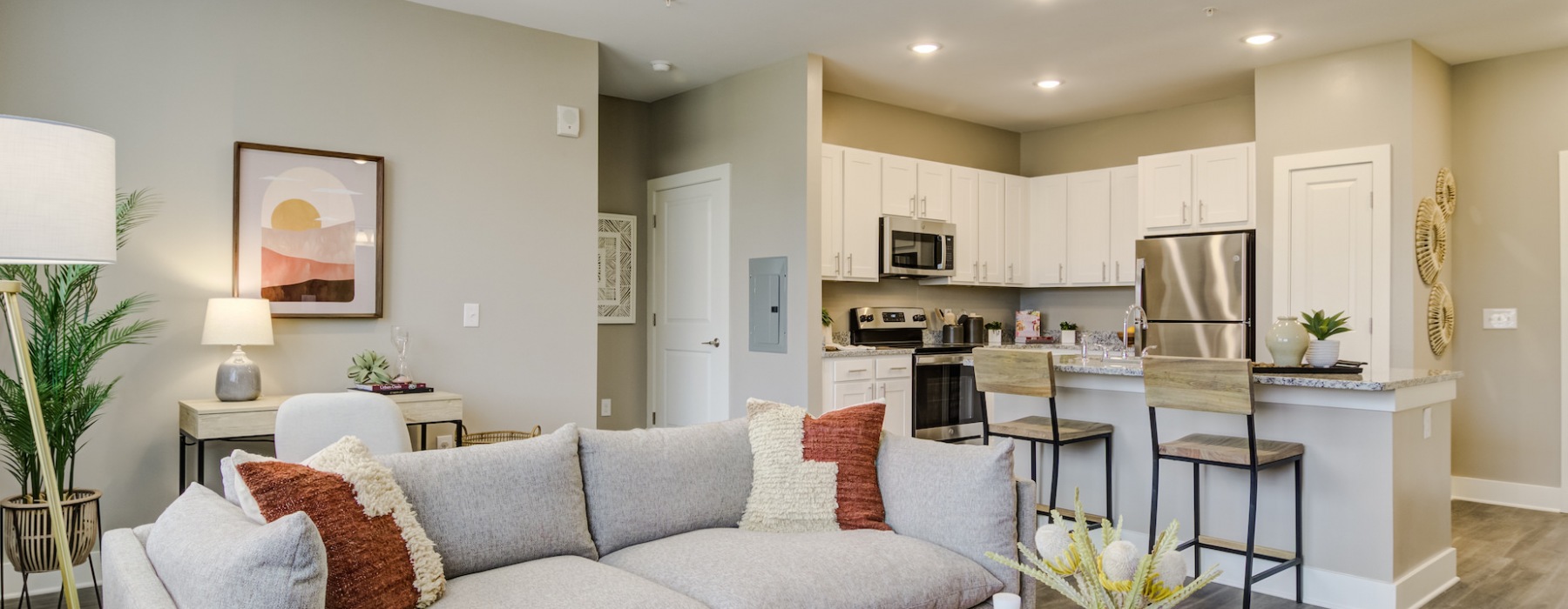Spacious and well lit kitchen with wood floors and stainless steel appliances. 