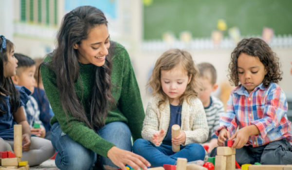 Teacher playing blocks with children