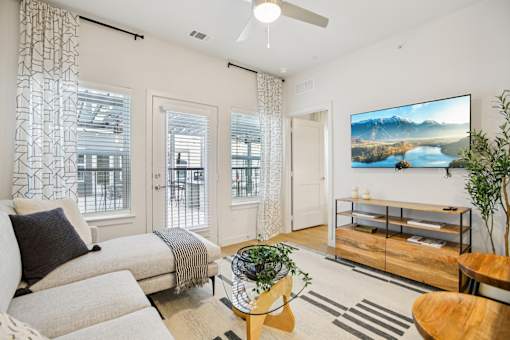 Modern living room with media console and ceiling fan at Matador Apartments, Austin, 78745