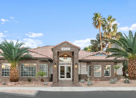 a home with a tile roof and palm trees in front of it