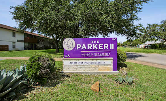 A sign for The Parker II Apartments is displayed in front of a building.