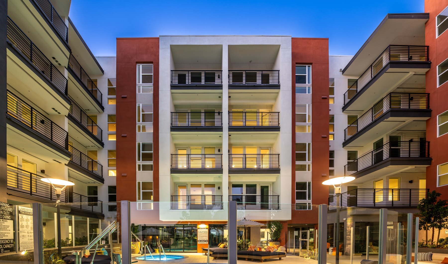 Tenney North Park gated in pool area with lounge beds surrounded by apartment buildings in San Diego.