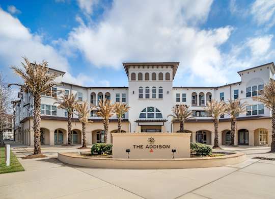 The front of a white building with a sign that says at The Addison,Louisiana