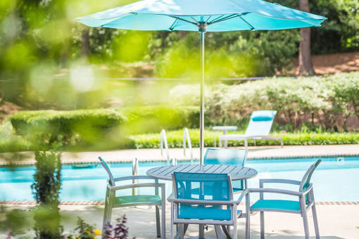 Swimming pool at Remington Place Apartments in Raleigh, NC with outdoor lounge chairs and resort-style seating