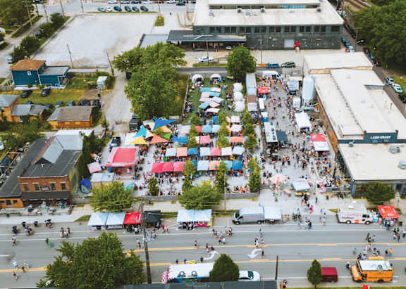 A busy street scene with a market in the middle.