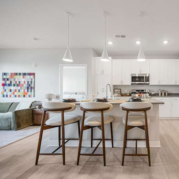 A kitchen with white cabinets and a white fridge.